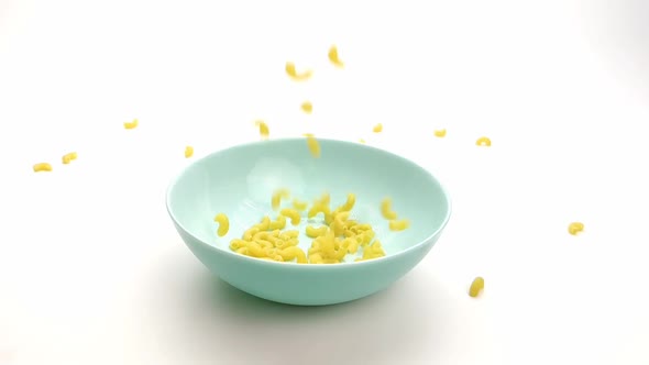 Raw Macaroni Pour Out on a Blue Plate Slow-down, Close-up alt