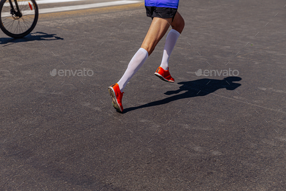 legs runner in compression socks running on marathon