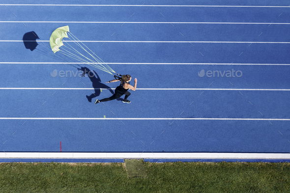 Top view of female runner with parachute on tartan track