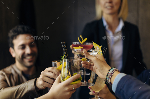 Colleagues toasting with cocktails in a bar