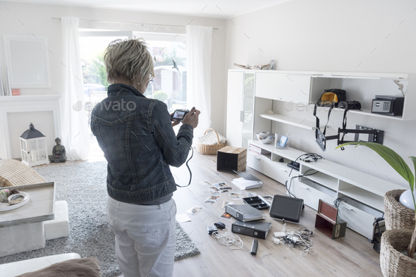 Woman photographing chaos after burglary when coming back in her one-family house