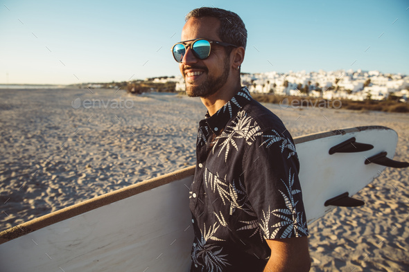 Man at the beach carrying surfboard Stock Photo by westend61 | PhotoDune