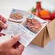 Close Up Of Hand In Kitchen Holding Recipe Cards For Online Meal Food Recipe Kit Delivered To Home - PhotoDune Item for Sale