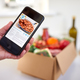 Hand In Kitchen Holding Phone With Recipe For Online Meal Food Recipe Kit Delivered To Home - PhotoDune Item for Sale