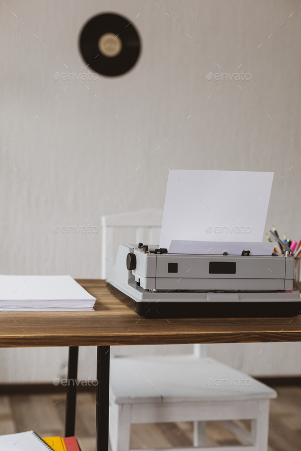 Stack of paper and vintage old typewriter at wooden desk table. - Stock Photo - Images
