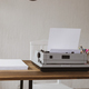 Stack of paper and vintage old typewriter at wooden desk table. - PhotoDune Item for Sale