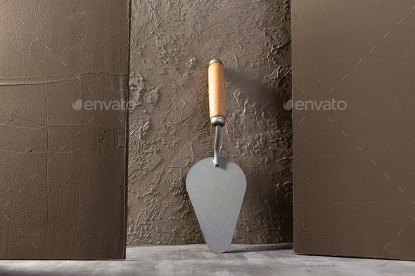 Concrete wall with construction trowel tool. Construction concept - Stock Photo - Images