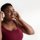 Closeup portrait of cheerful chubby black lady with wireless headset - PhotoDune Item for Sale