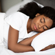 Closeup shot of young african american woman sleeping in bed - PhotoDune Item for Sale