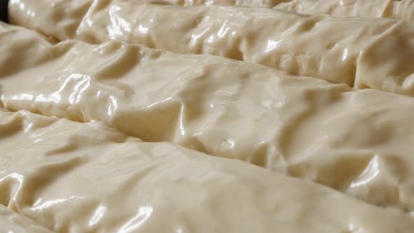 Spreading fat and egg rolled thin sheets of dough with filling 4K 2160p 30fps UHD footage - Oiling   alt