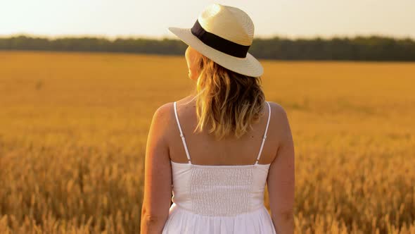 Woman in Straw Hat on Cereal Field in Summer alt