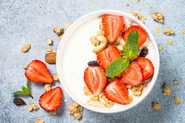 Yogurt with granola and strawberry in white bowl Stock Photo by Nadianb