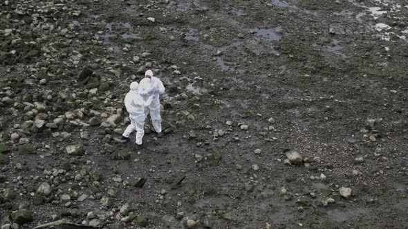 Forensic scientist taking sample at river bank