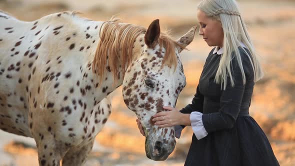 Young Blonde Woman Stroking And Hugging White Horse