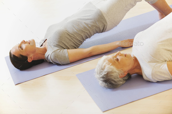 Two women arching back on gym mat