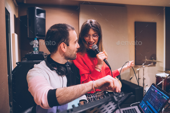 Young man and woman using mpc pad and singing