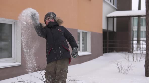 A little guy outside the house plays snowballs during the quarantine period. alt
