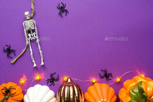 Halloween layout of garland of skeleton on a rope, glowing Jack o Lantern, pumpkins