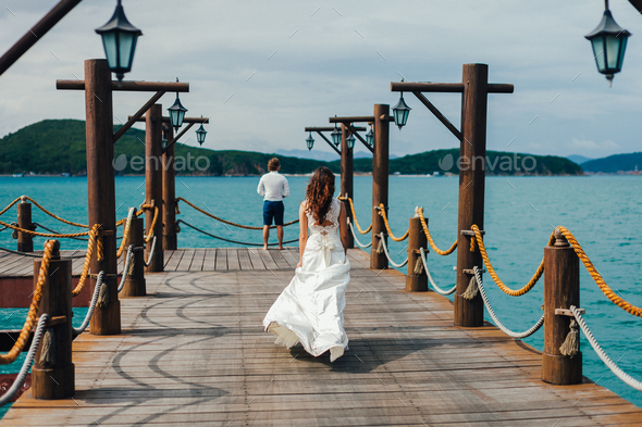 honeymoon couple walk on pier