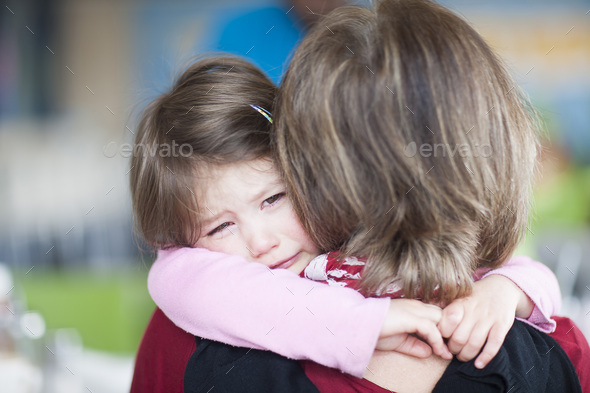 Girl crying in her grandmother\'s arms
