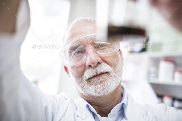 Man looking at beaker in laboratory