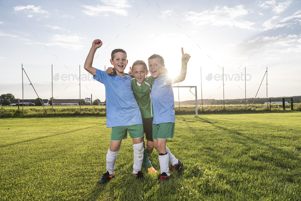 Young football players cheering on football ground