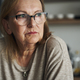 Thoughtful caucasian senior woman sitting in the kitchen and looking away - PhotoDune Item for Sale