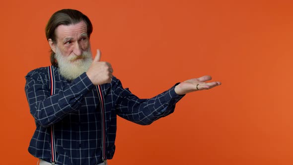 Mature Grandfather Showing Thumbs Up and Pointing Empty Place Advertising Area for Commercial Text alt