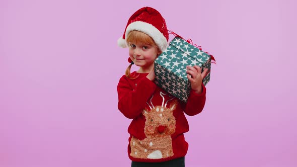 Funny Toddler Child Girl Wears New Year Sweater Received Present Interested in What Inside Gift Box alt