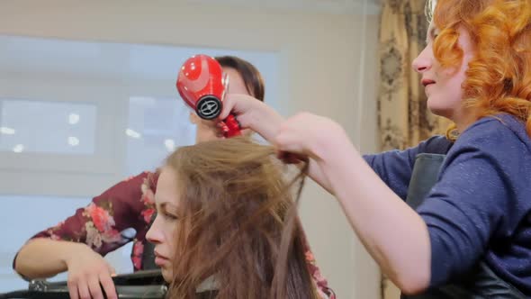 Skilled Hairdressers Create Hairstyle with Hairdryer Closeup alt