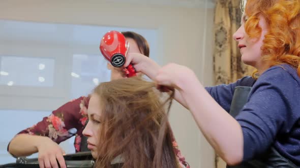 Skilled Hairdressers Create Hairstyle with Hairdryer Closeup