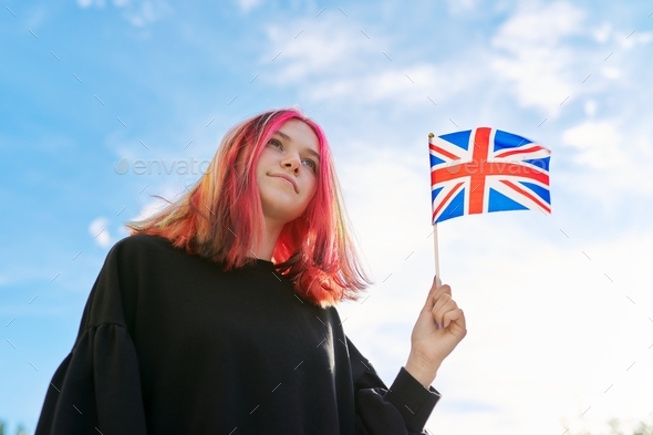 Female student teenager with British flag, blue sky with clouds background