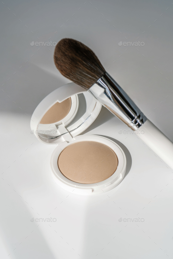 Powder and cosmetic brush on a white background.