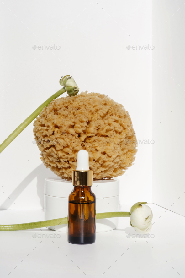 Serum and natural sea sponge on a light background.