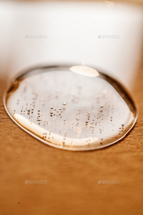 A drop of cosmetic gel on a beige background.