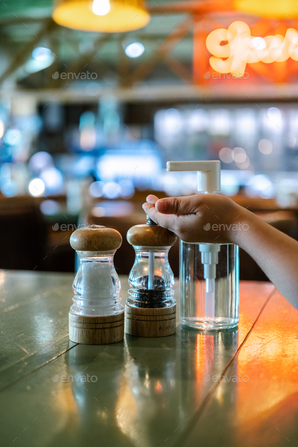 A salt and pepper shaker and an antiseptic stand on the table in a bar or cafe.