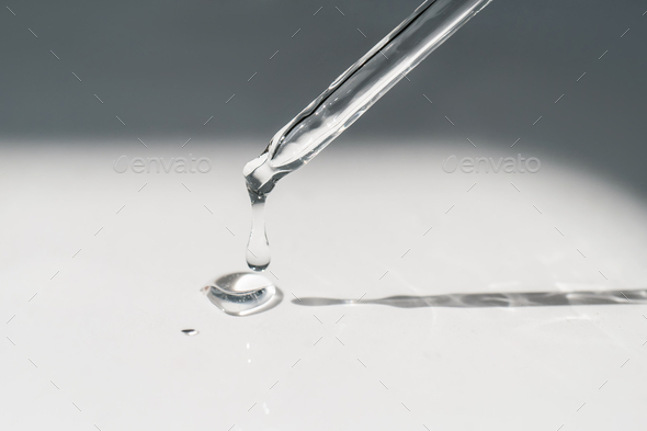 A drop of cosmetic oil falls from the pipette