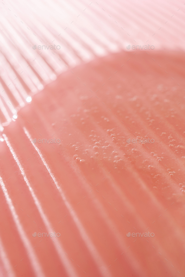 The gel flows over a pink fluted background