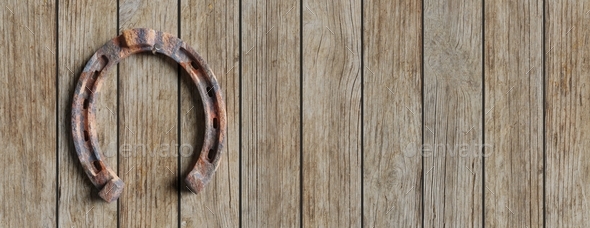 Rusty hanged horseshoe isolated on wooden empty background. Copy space, banner. 3d illustration