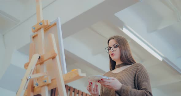Young and Pretty Girl Learns to Draw in an Art Studio alt