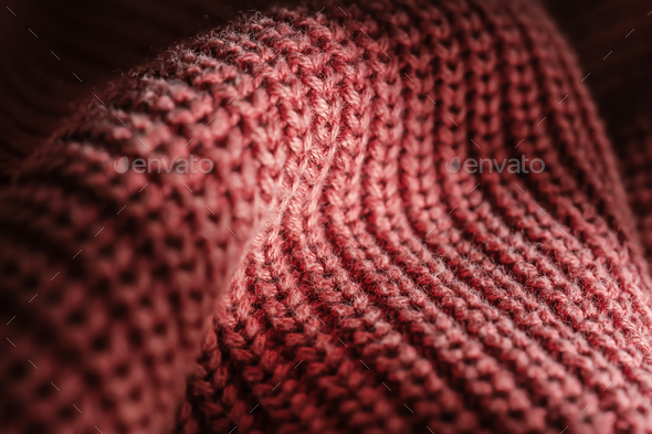Knitted texture of a pink sweater or scarf close-up.