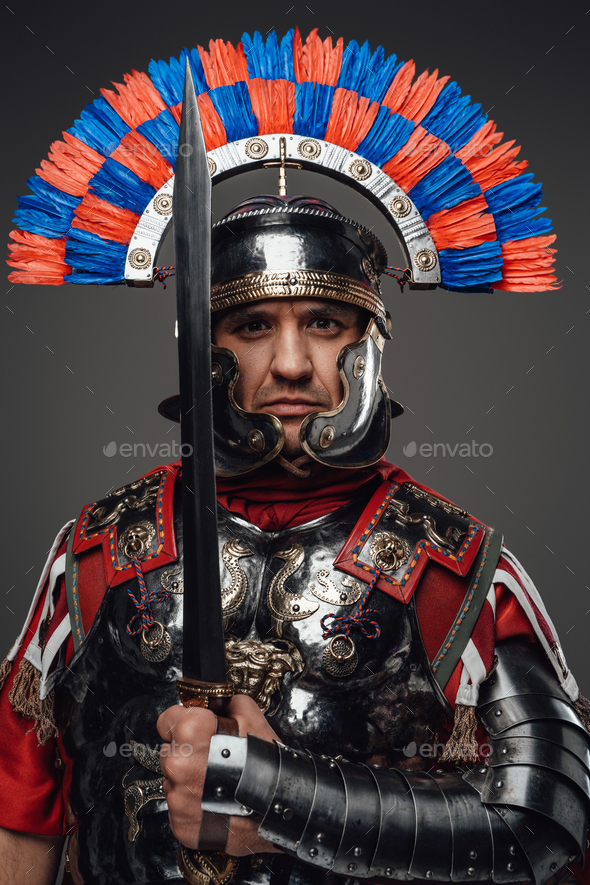 Proud roman soldier with gladius posing against gray background Stock ...