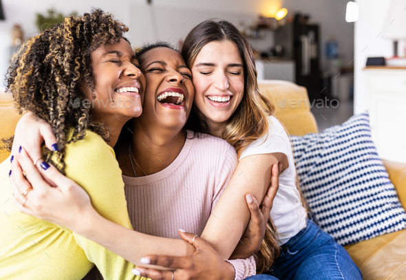 Three happy multiethnic female best friends laughing together