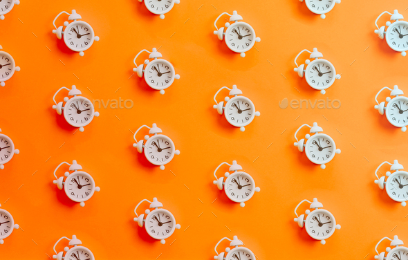 Minimal patter of a white clock over a orange bright background, copy space, minimal design