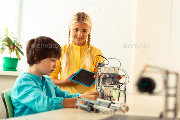 Girl Standing Near Her Classmate Building A Robot Stock Photo By Iakobchuk