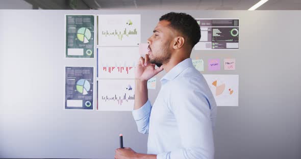 Professional businessman holding marker pen talking on the phone in modern office in slow motion alt