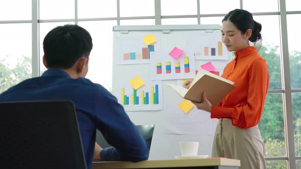 Young Woman Explains Business Data on White Board alt