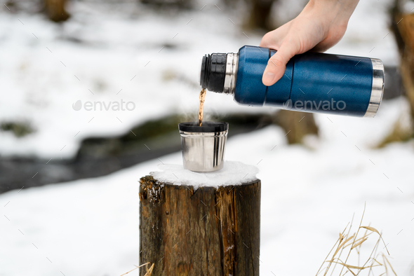 Close-up of Man Holding Thermos and an Iron Mug, Pouring Hot Tea