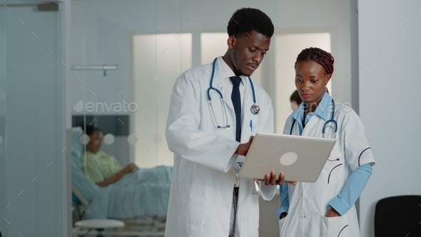 African american doctors looking at laptop to find treatment
