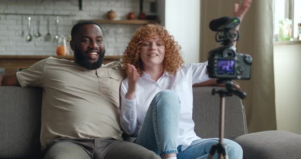 Couple Bloggers Recording Video for Internet with Professional Video Camera Mounted on Tripod alt